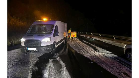 Trafikkbetjent, patruljebil og skilt med teksten stengt vei.