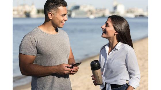 Mann og kvinne snakker sammen på en strand