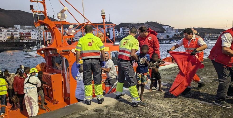 Flyktninger hjelpes i land av redningspersonell.